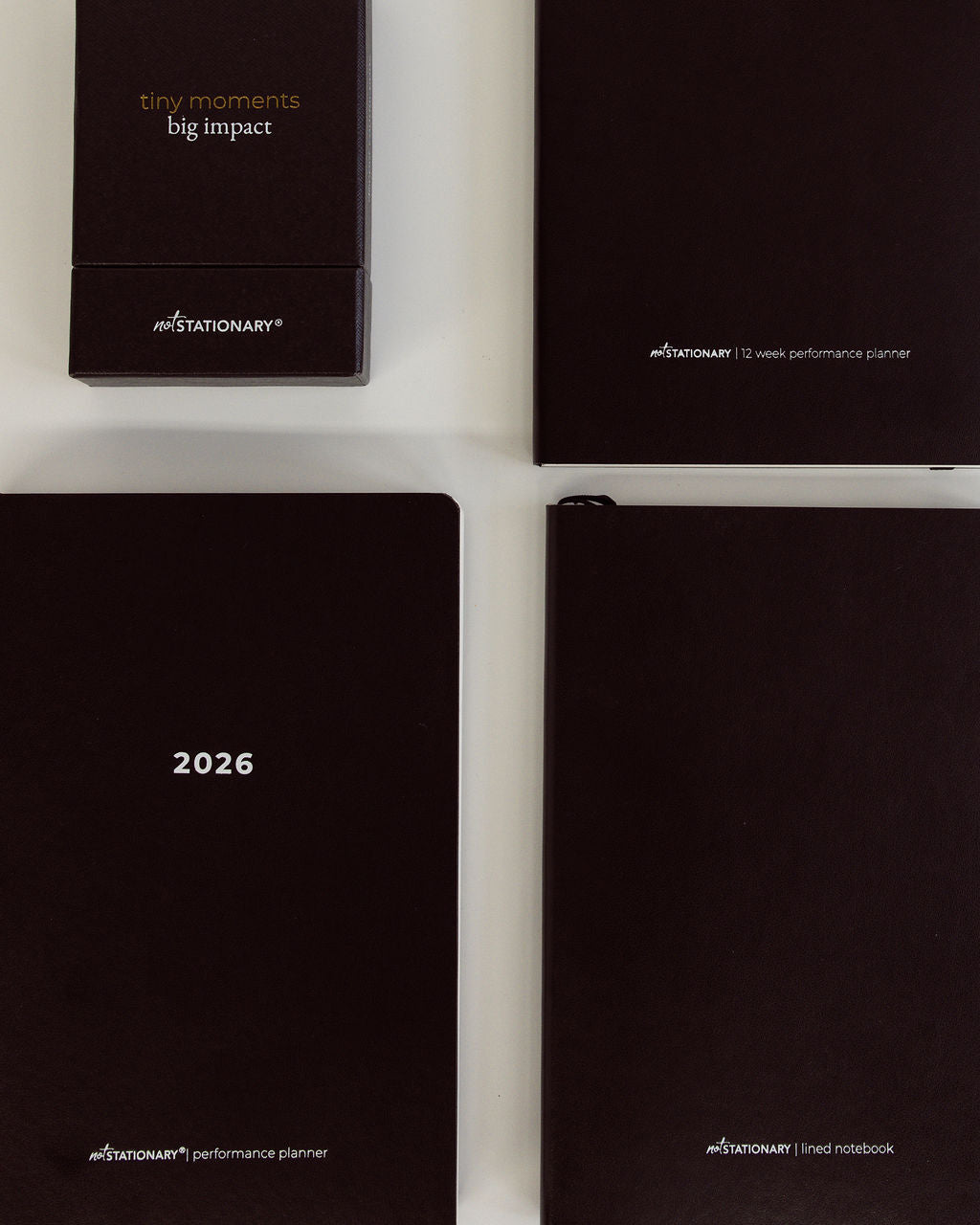Three black planners and conversation cards from notSTATIONARY on a white background
