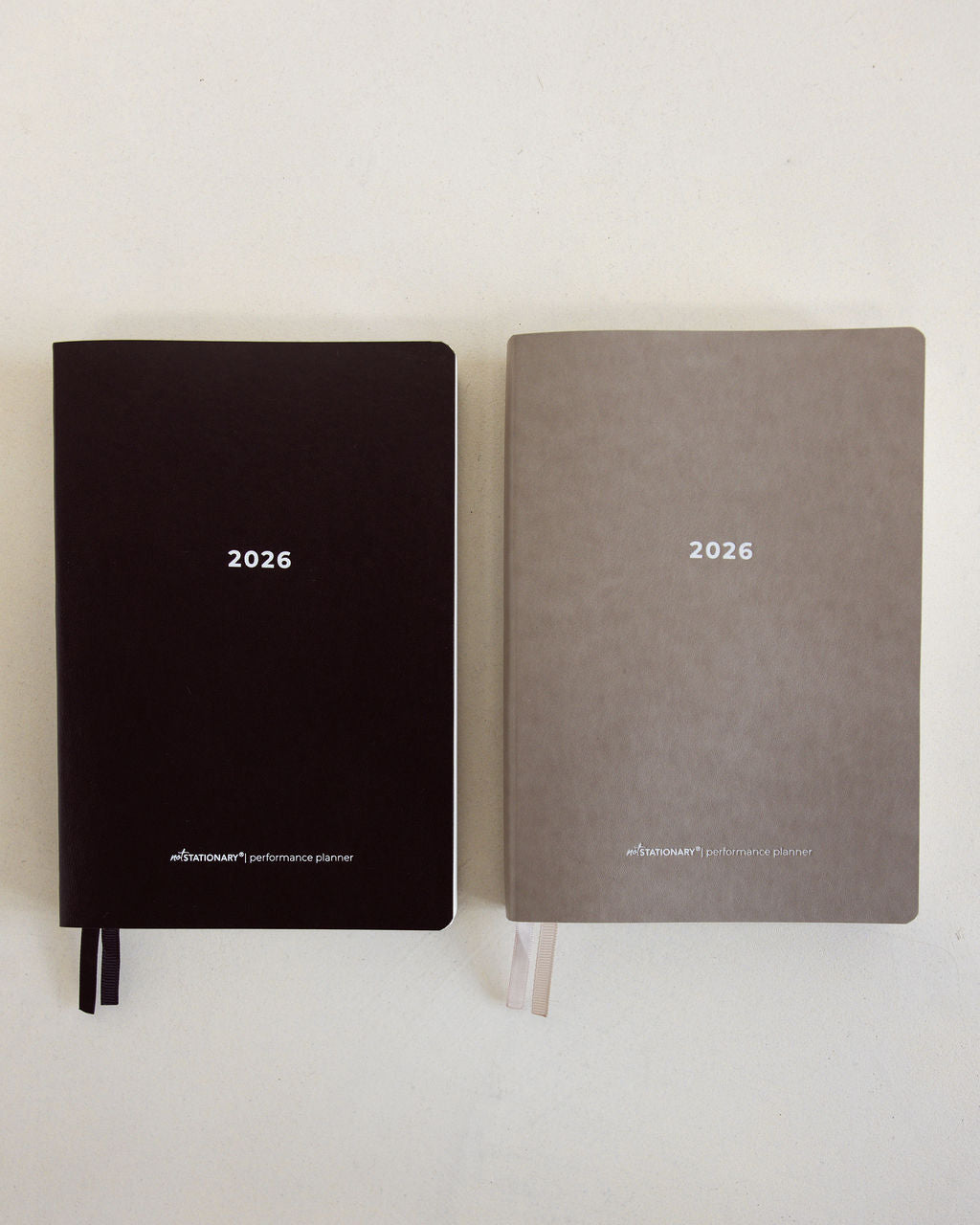 2026 Not Stationary Performance Planners in minimalist black and stone covers with ribbon bookmarks, designed for intentional living and high performance.