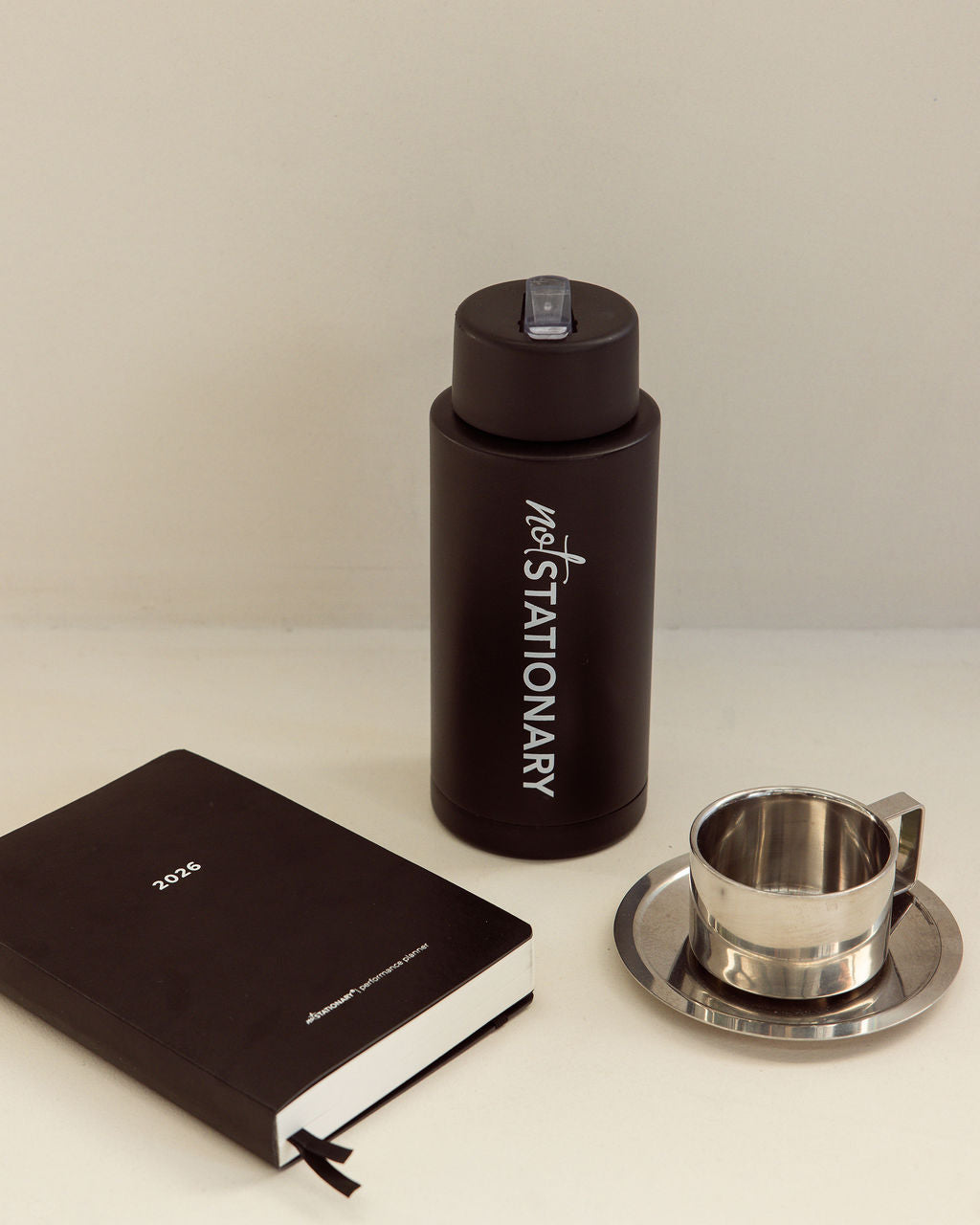 Not Stationary Signature Drink Bottle and Performance Planner on desk — the perfect setup for productivity and daily rituals.