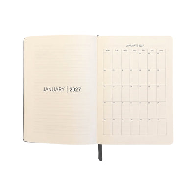 An open planner or notebook showing January 2027 on both the lined left page and the calendar grid right page, photographed on a clean white background.